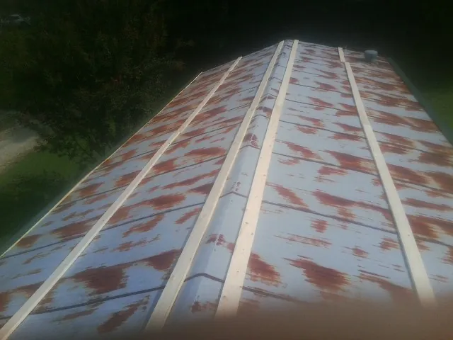 Rusted metal roof panels with new wood purlins before replacement — Storm Damage Roof Repair in Conneautville by Roofing Brothers