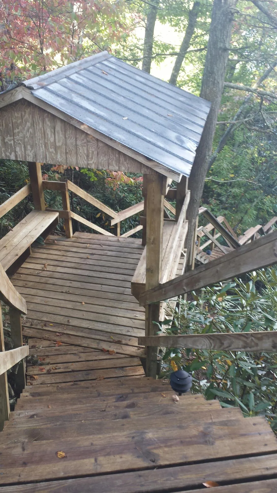 Metal roofed shelter over wooden steps on a wooded walkway — Skylight Repair & Installation work by our crew in Conneautville