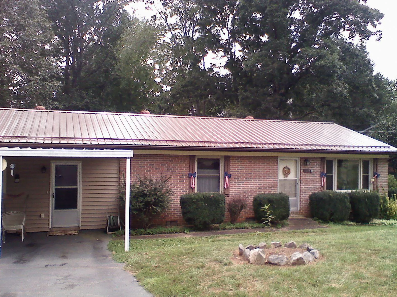 Bronze metal roof and carport on a brick ranch home — Roof Repair work by our crew in Conneautville